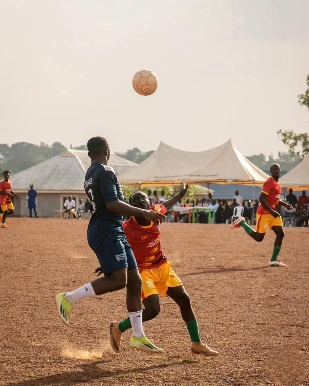 Youth playing in Ham Soccer tournament with community watching